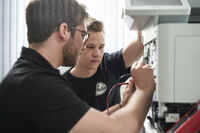 Zwei Techniker von bueroboss.de/giegler reparieren einen Drucker