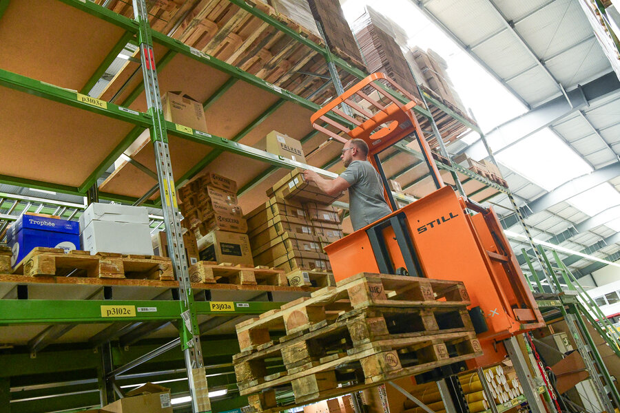 Volle Lagerregale in der Logistik mit einem Gabelstapler im Gang
